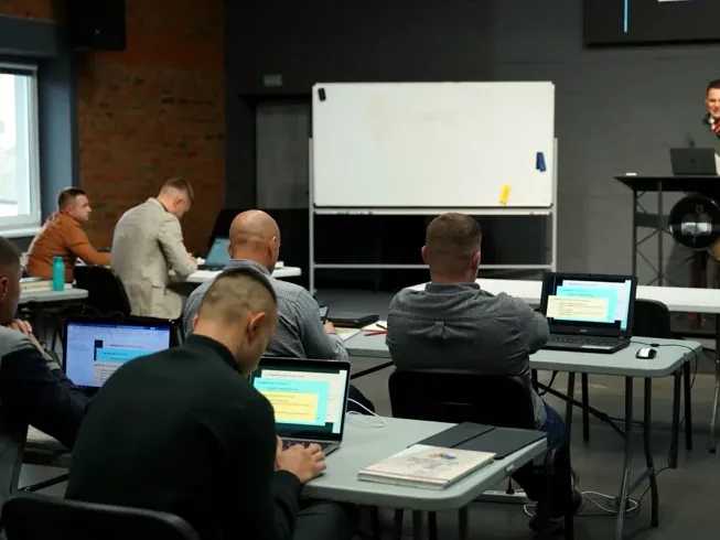 A class in session: students at laptops, the instructor at the lectern